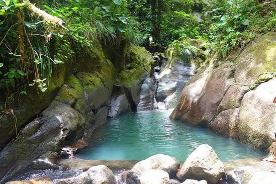 Le bassin turquoise des chutes de Moreau, entouré de roches moussues