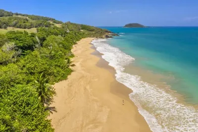 La plage de Cluny vue du ciel, sable clair entre la forêt et le récif