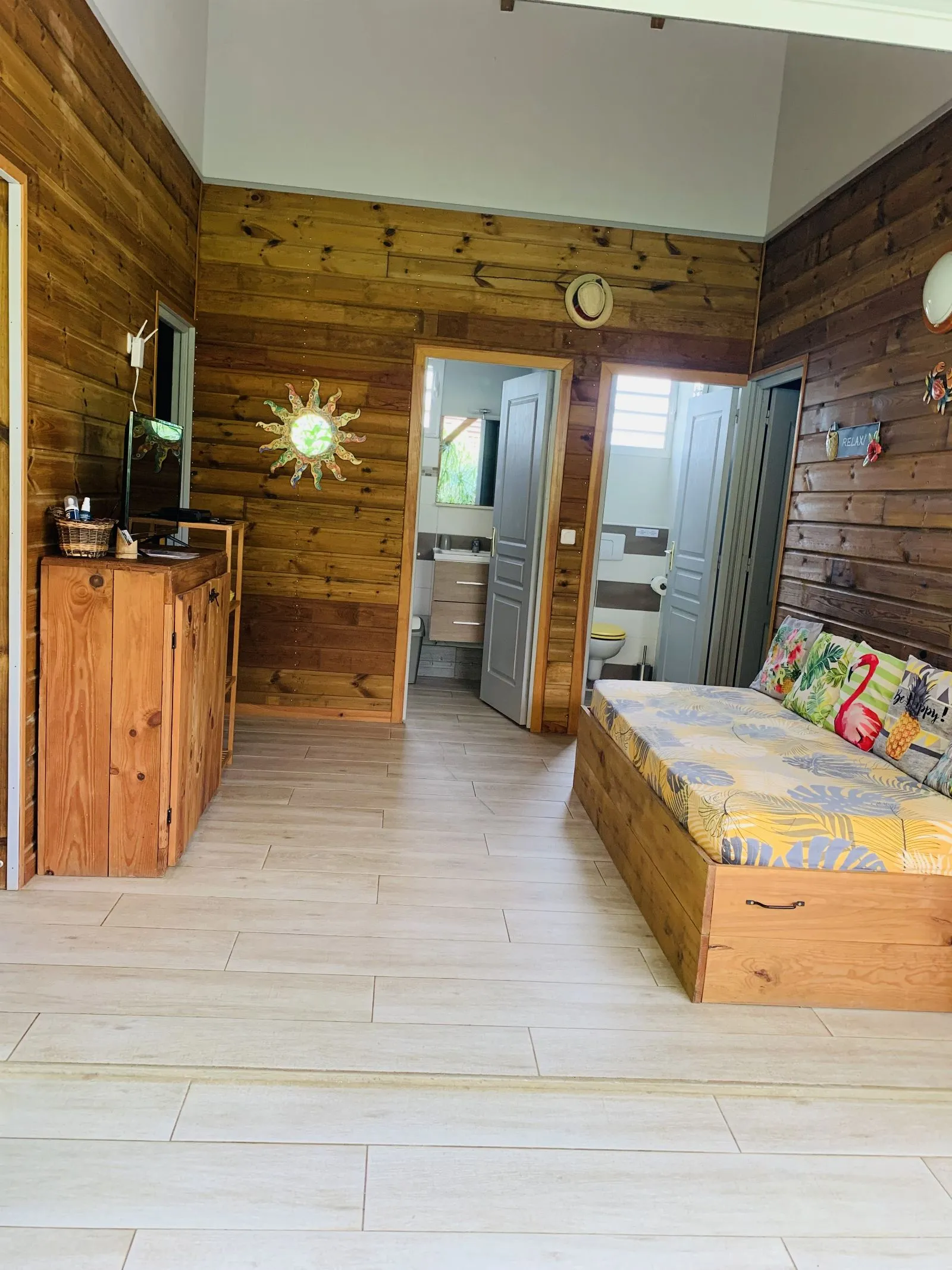 Pièce à vivre lambrissée avec commode, banquette et accès à la salle d’eau