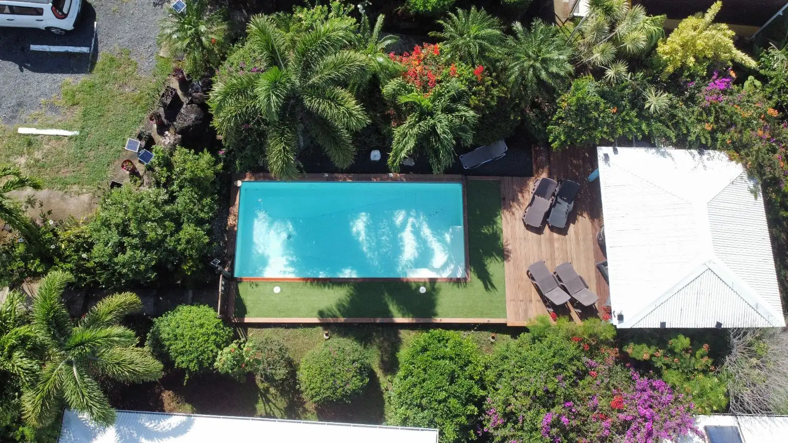 La piscine vue de haut, avec sa plage de bois et ses transats